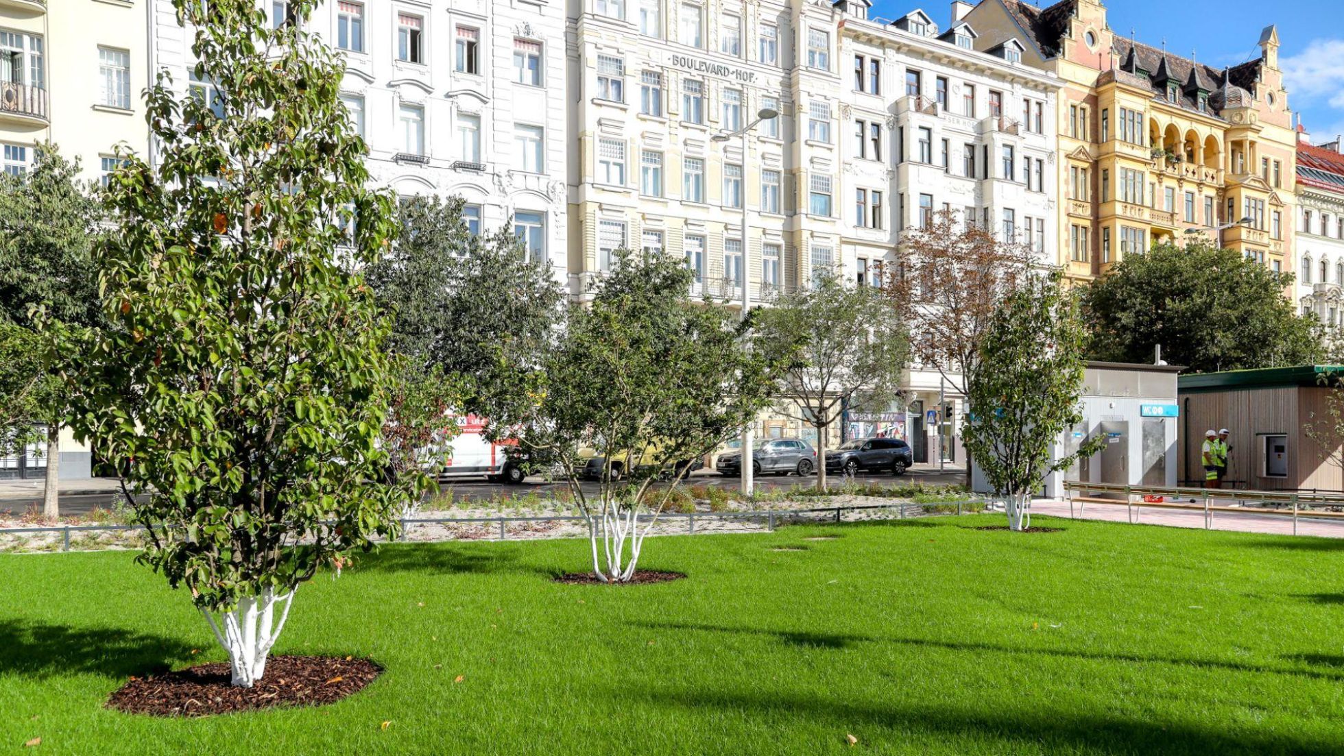 copyright: Stadt Wien/Christian Fürthner Grüner Park mit Bäumen und frisch gepflanztem Rasen, im Hintergrund Altbauten.