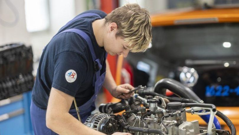 copyright: Stadt Wien/Bubu Dujmic Junger Lehrling schraubt in Arbeitskleidung an einem Motor