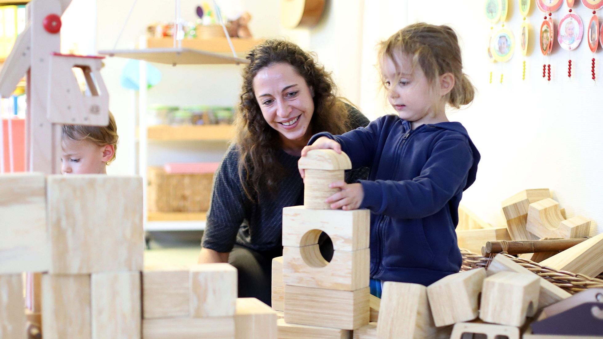 copyright: MA10 Wiener Kindergärten/VOTAVA Eine Mutter spielt mit ihrem Kind mit Holzbausteinen.
