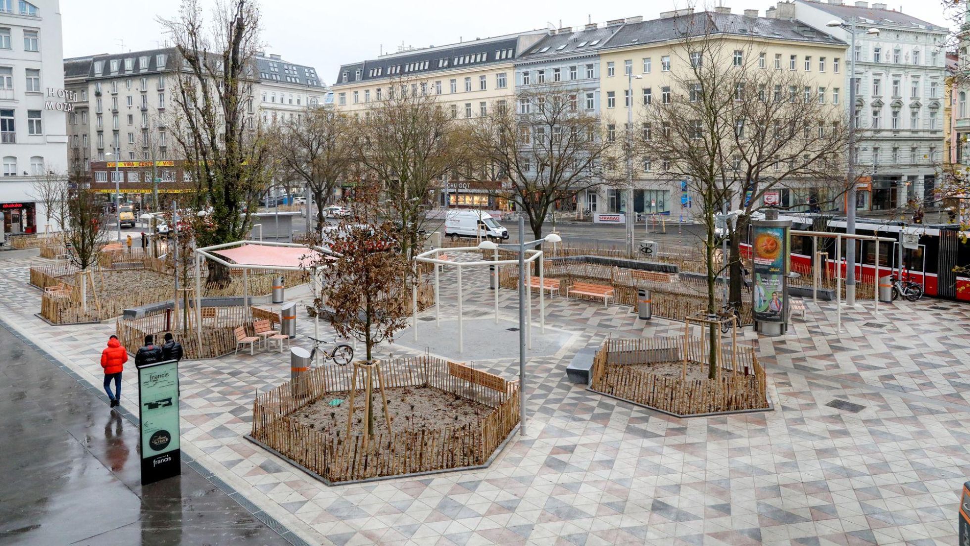Platz mit Bäumen und Beeten, Wasserspiel und Sitzgelegenheiten