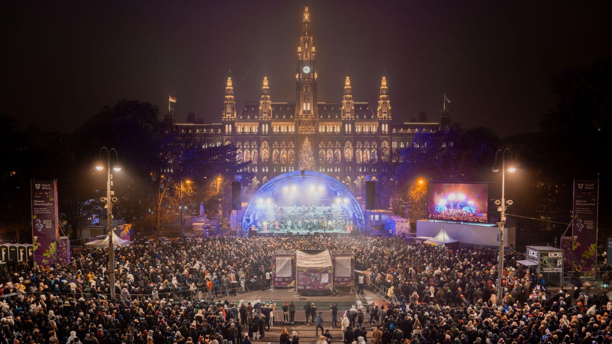 copyright: Stadt Wien Marketing GmbH / Christian Kremser Bühne vor beleuchtetem Rathaushaus mit vielen Gästen am Silvesterpfad