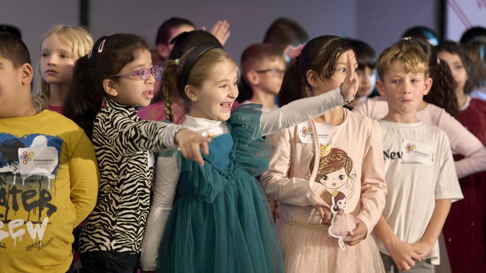 Kinder stehen versammelt, lachen und winken