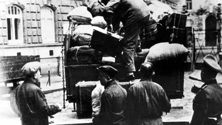 A member of the SS oversees the loading of the luggage of Viennese Jews singled out for deportation