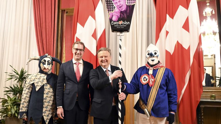 copyright: Stadt Wien/Christian Jobst Bürgermeister Michael Ludwig, Conradin Cramer, Regierungspräsident des Kantons Basel-Stadt, sowie 2 Mitglieder der Basler Fasnachtsgilde mit der ESC-Fasnachtslaterne.