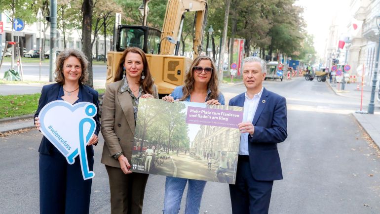 copyright: Stadt Wien/Christian Fürthner 3 Politikerinnen und 1 Politiker halten eine Visualisierung des neugestalteten Radwegs am Ring.
