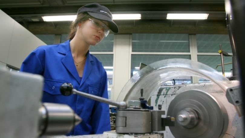 copyright: Bilderbox Weiblicher Lehrling steht vor Maschine