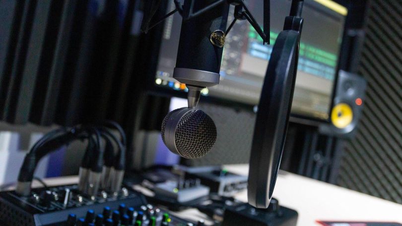 Podcast-Studio mit professionellem Mikrofon, Tontechnik und Monitor.