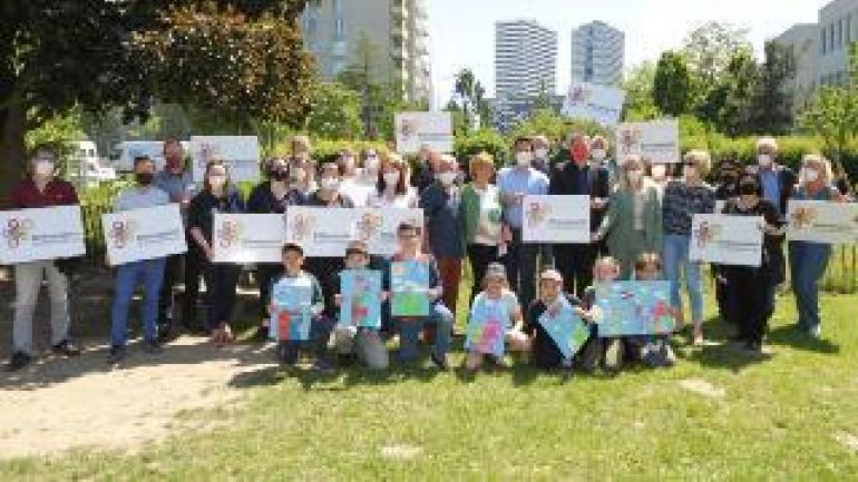 Gruppe von Menschen mit Schild "Bildungsgrätzl Großfeldsiedlung"