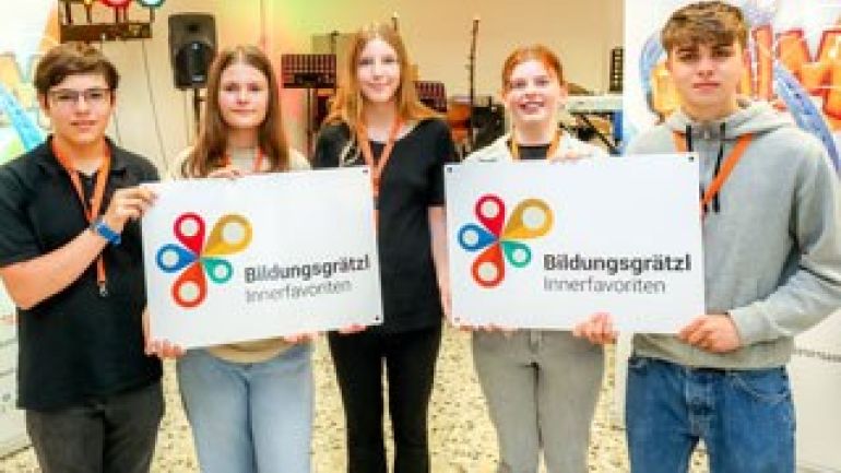 5 Jugendliche halten 2 Plakate "Bildungsgrätzl Innerfavoriten"