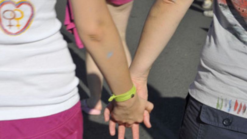 Zwei Frauen halten Händchen.