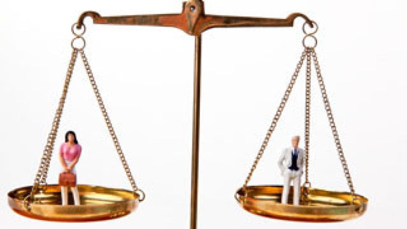 Waagschale mit einer Frauen-Plastikfigur und eine weitere mit einer Männer-Plastikfigur