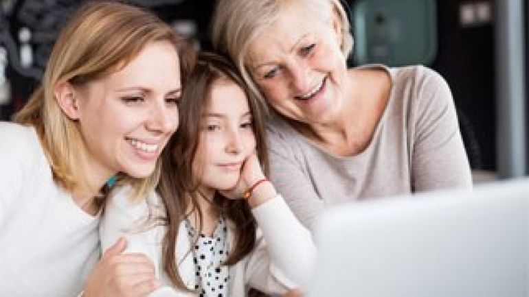 copyright: iStock/Charday Penn 2 Frauen und 1 Mädchen vor einem Laptop