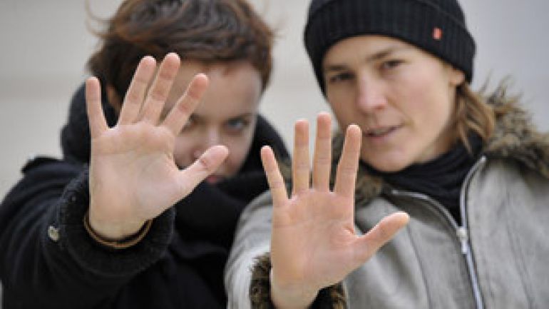 Zwei Frauen heben abwehrend die Hände