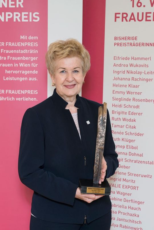 Frau hält Statue bei Preisverleihung