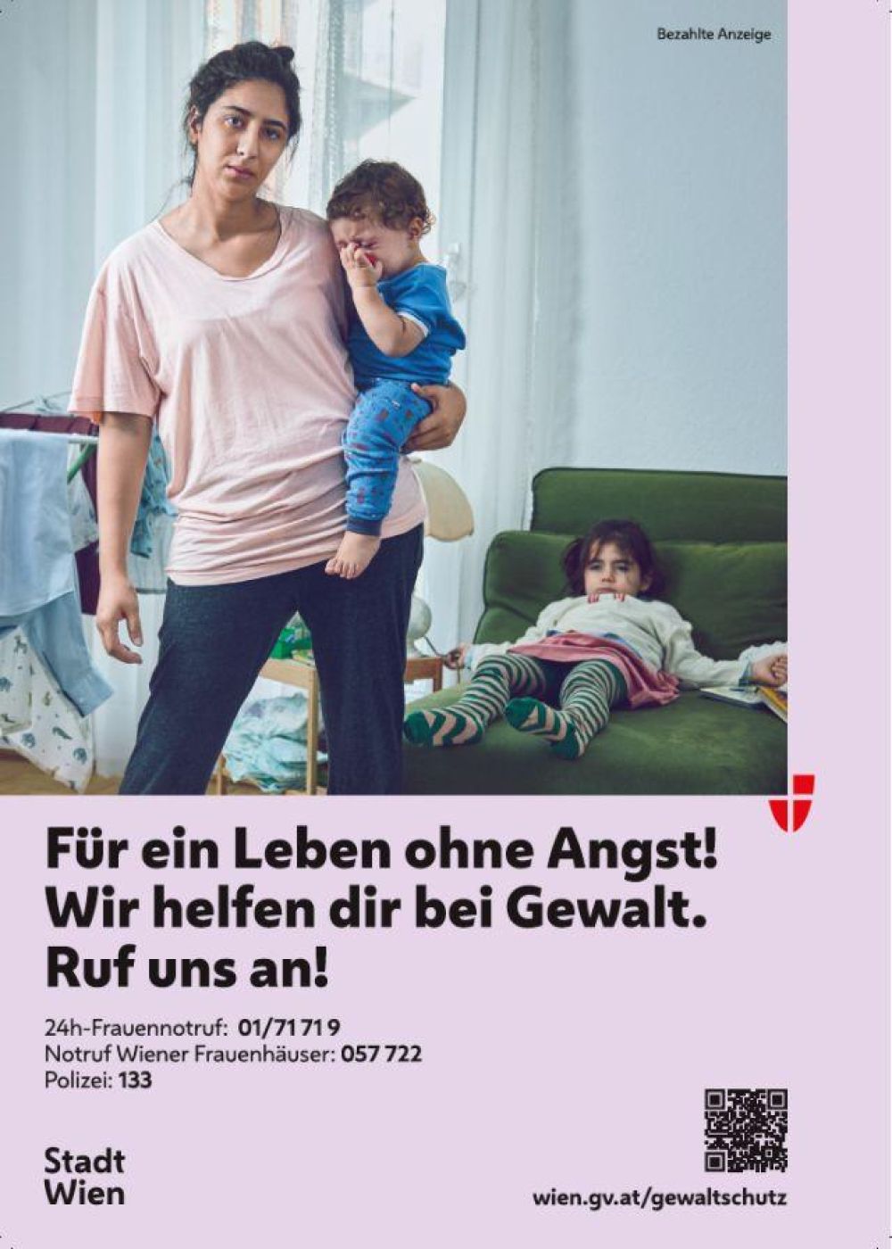 <p>Sujet zur Kampagne</p> Eine junge Frau steht im Wohnzimmer mit dem Rücken zur Couch. Sie trägt ein weinendes Kleinkind auf der Hüfte, im Hintergrund liegt ein Mädchen ermattet auf der Couch. Alle wirken unglücklich.