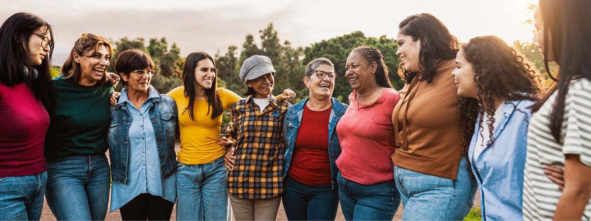 Frauen mit unterschiedlichem Alter und ethnischem Hintergrund stehen fröhlich nebeneinander