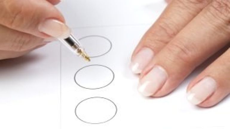 copyright: Bohmann - Katrin Bruder Hands of a woman filling out a ballot