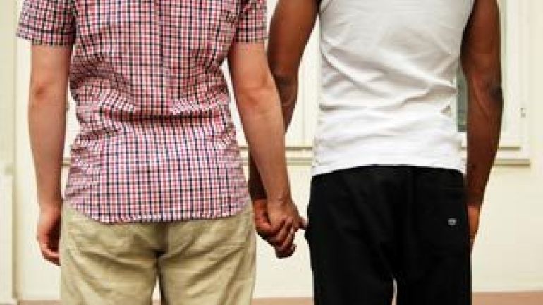 Zwei Männer von hinten, die sich an den Händen halten