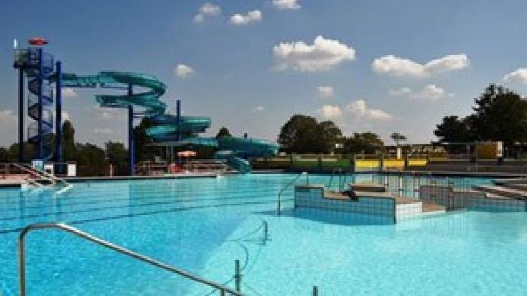 Schwimmbecken mit Rutsche im Hintergrund