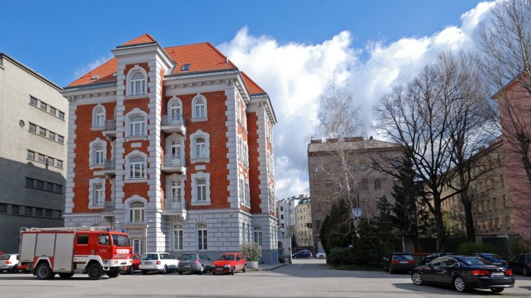 Blick auf die Wache, ein mehrstöckiger Ziegelbau in rot und weiß