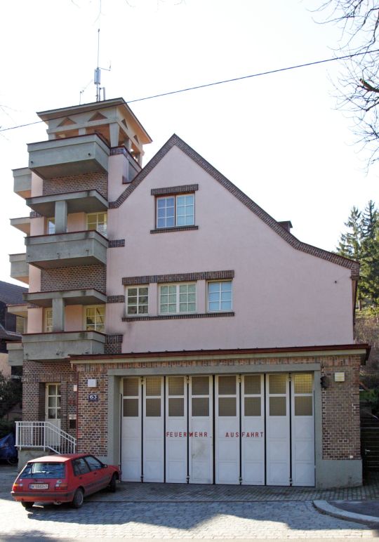 Blick auf den Garagenbereich der Wache mit einem großen Tor, davor ein parkendes Auto