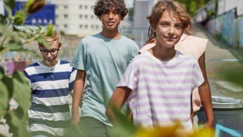 copyright: Mobilitätsagentur / Christoph Meissner Kinder und Jugendliche marschieren in der Stadt neben Blumen