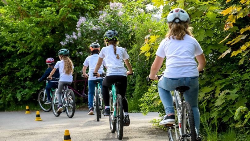 Mädchen fahren hintereinander mit dem Fahhrad