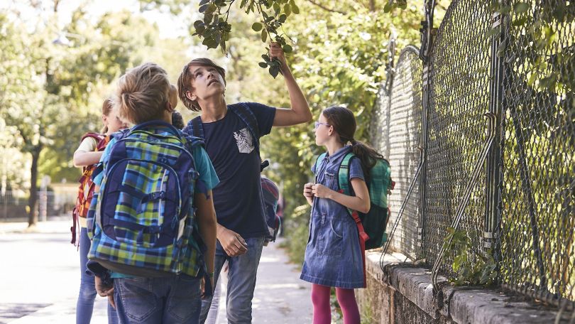 copyright: Mobilitätsagentur / Christian Fürthner 4 Kinder stehen mit Schultaschen am Gehsteig.