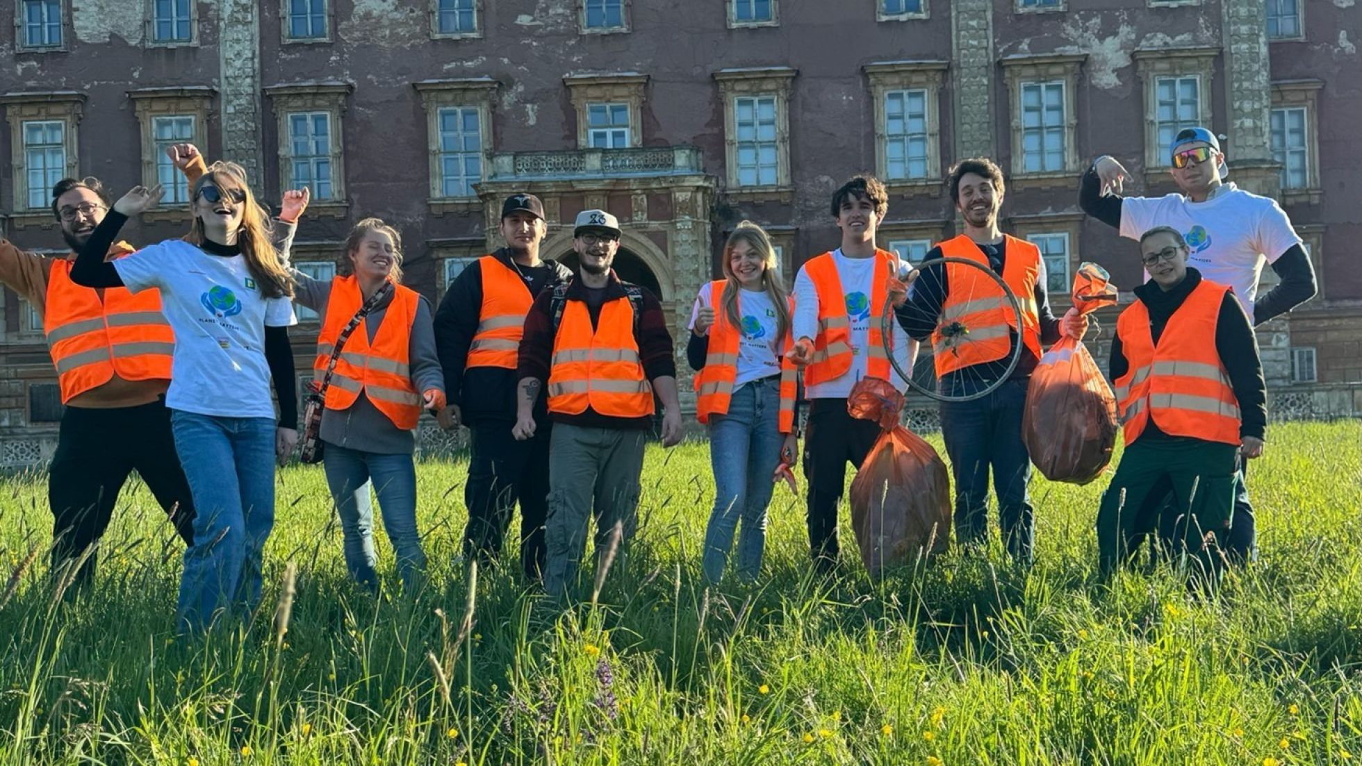 Menschen in Warnwesten halten Müllsäcke in die Höhe