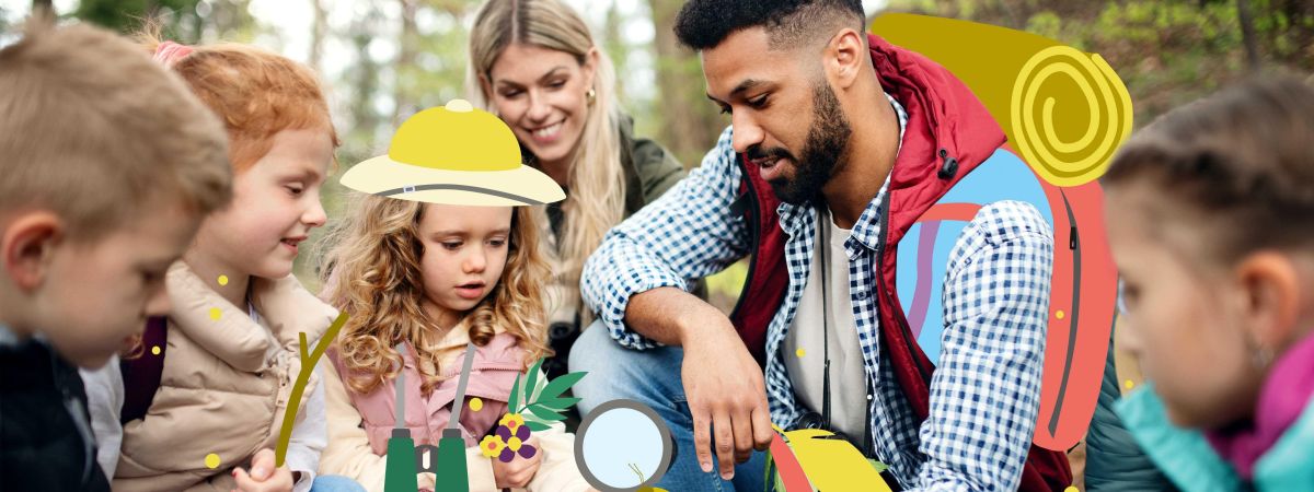Eine Kindergruppe ist mit einem Betreuer und einer Betreuerin im Wald und erkundet die Natur