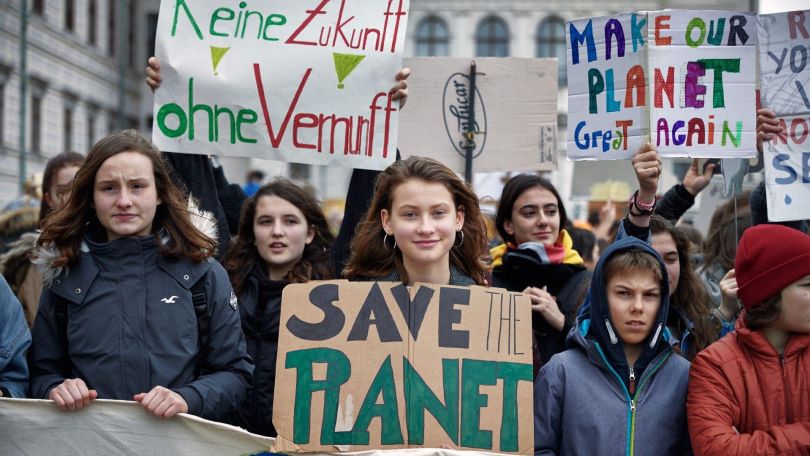 Menschen bei einer Klima-Demo halten Plakate in die Höhe.
