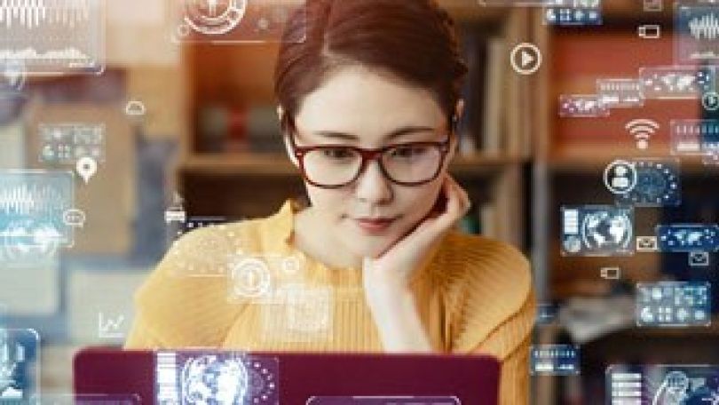 Frau vor einem Laptop umringt von wissenschaftlichen Symbolen