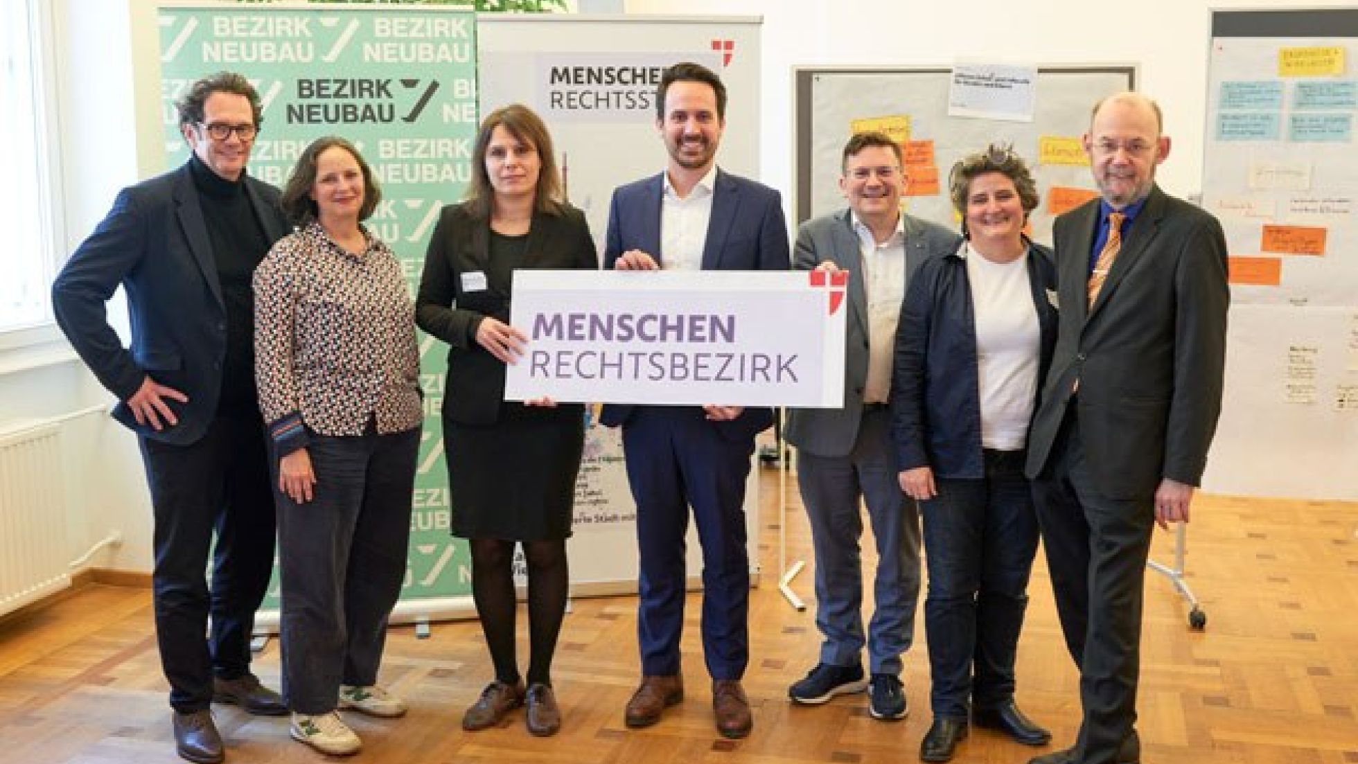 Gruppenfoto mit Menschen, die Banner halten mit Text "Menschenrechtsbezirk"