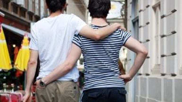 Zwei Frauen, die Arm in Arm gehen, von hinten