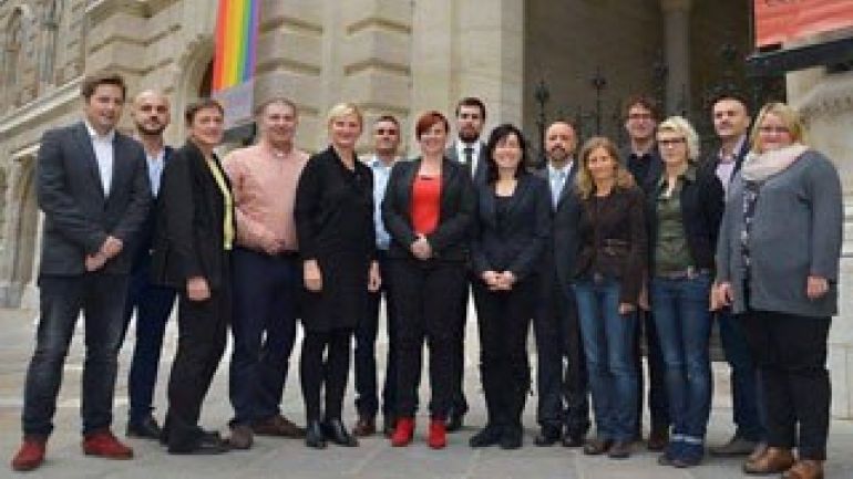 Mehrere Personen aufgreiht nebeneinander vor dem Wiener Rathaus