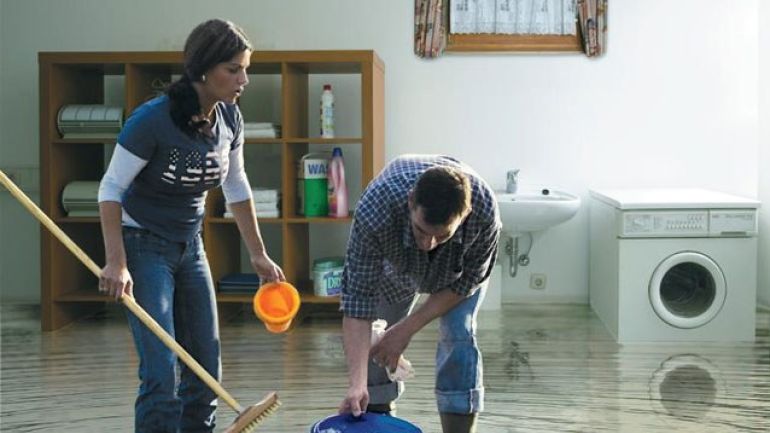 copyright: Kessel Frau und Mann mit einem Kübel in einem überfluteten Keller