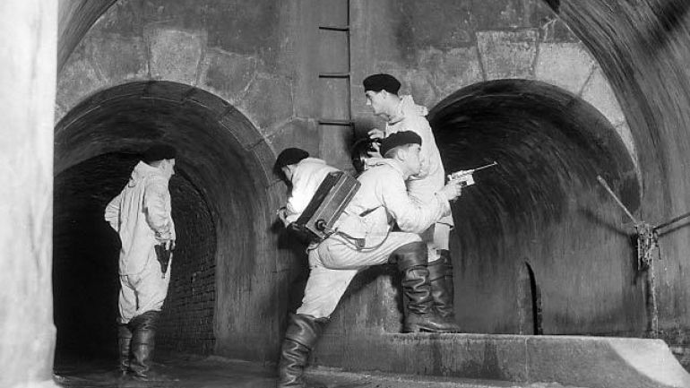 Vier Männer der Kanalbrigade im Kanal