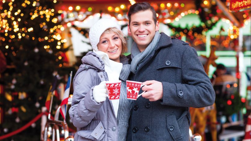2 Personen, die mit einem Punschhäferl anstoßen