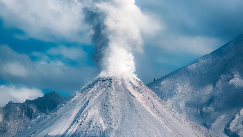 copyright: TaW Foto von einem Vulkan aus dem eine dicke Rauchwolke aufsteigt