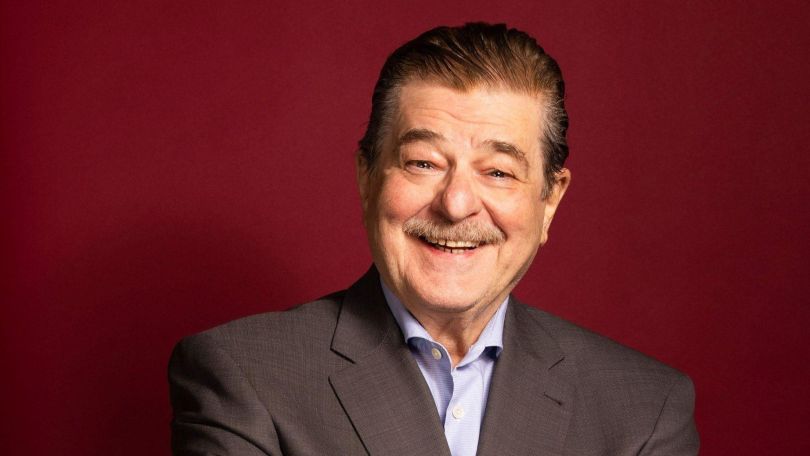 Foto von Erwin Steinhauer vor weinrotem Hintergrund