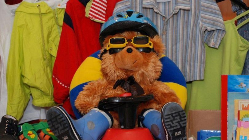 copyright: WHW / NBZ 7 Kindergewand und Plüschbär in der Mitte, der Helm und Stiefel anhat.