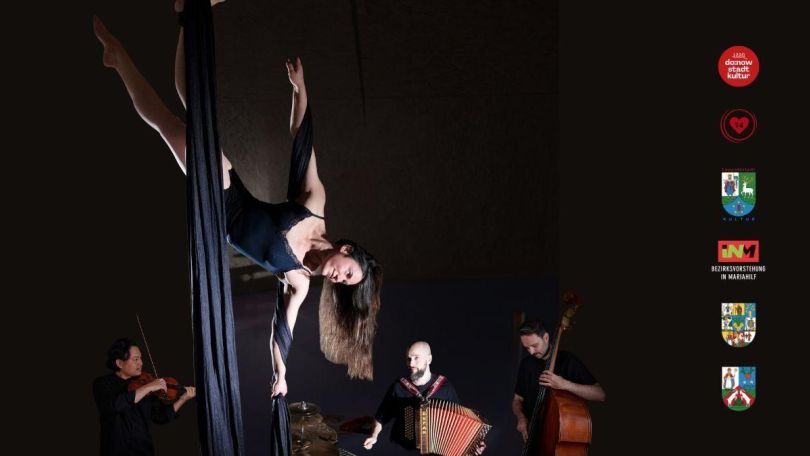 copyright: head cinema Seiltänzerin mit langen braunen Haaren in dunkelblauem bodysuit, im Hintergrund drei Musiker mit Streichinstrumenten und Akkordeon.