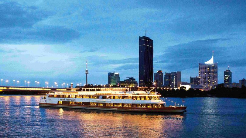 copyright: DDSG Blue Danube Ausflugsschiff unterwegs auf der Donau, im Hintergrund der blaue Abendhimmel