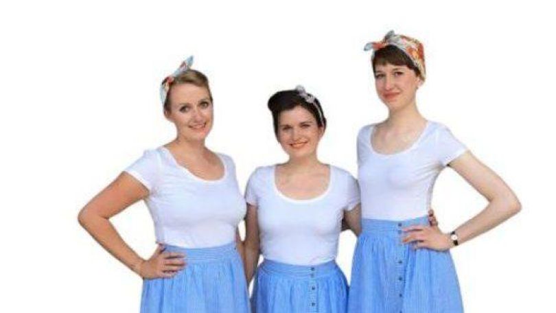 copyright: Die Margaritas Die drei Sängerinnen von "Die Margaritas" in blauen Röcken und weißen Blusen schauen in die Kamera und lächeln.