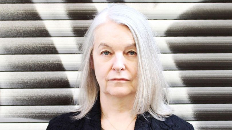Porträt einer Frau mit langen weißen Haaren und schwarzer Bluse.