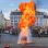 copyright: Stadt Wien – Feuerwehr Ein Feuerwehrmann löscht beim Feuerwehrfest einen riesigen Feuerball auf einem Platz in der Innenstadt. Hinter Absperrungen verfolgen viele Zuseher die Vorführung.