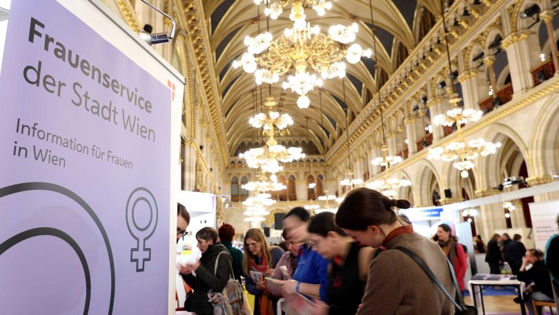 copyright: Stadt Wien/Martin Votava Personengruppe im Rathaus und Banner mit Aufschrift "Frauenservice der Stadt Wien - Informationen für Frauen in Wien"