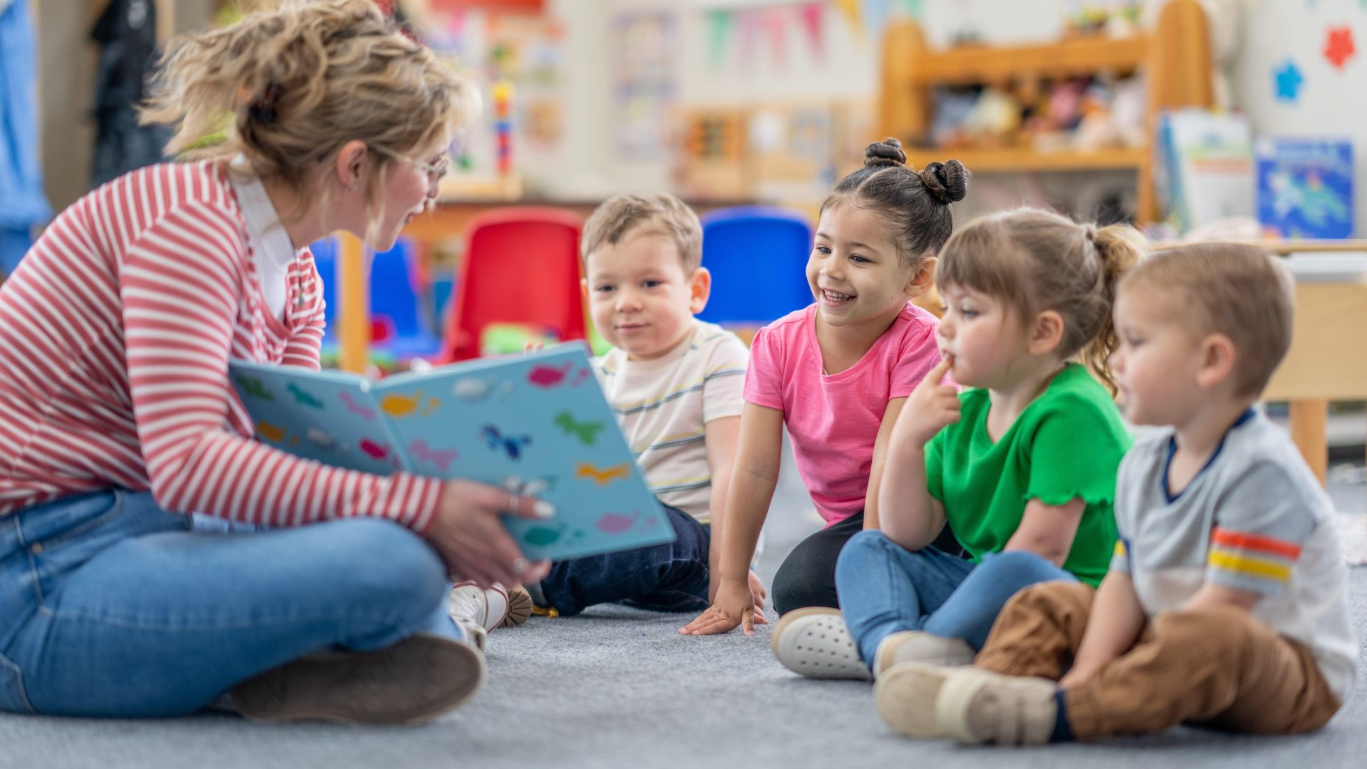 Eine Kindergärtnerin liest Kindern vor