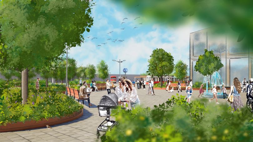 Auf dem Platz vor dem Bahnhofseingang stehen viele Bäume. Dazwischen gehen Menschen. Kinder spielen bei einem Wasserspiel.