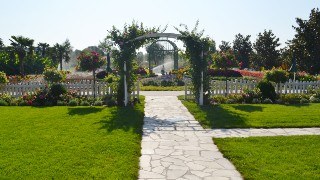 Large garden with lots of greenery, flowers, and an archway